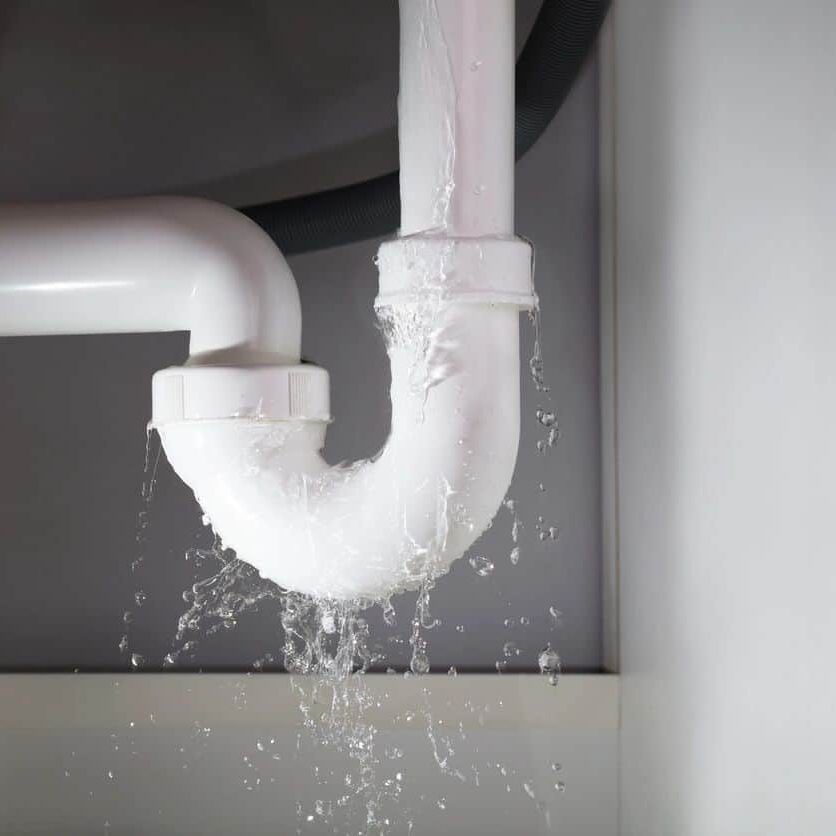 Leaking plumbing under sink, plumber emergency repair, plumbing leak fix, water dripping from pipe, bathroom plumbing repair, Cornwell Plumbing services, professional plumbing solutions, plumbing leak detection, residential plumbing repair, expert plumber providing emergency services.