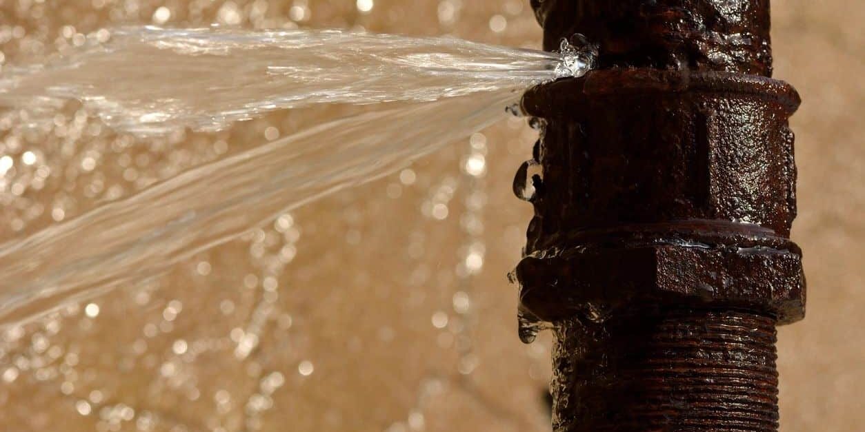 Corrosion and water leak on old rusty pipe, plumbing repair and maintenance concept.