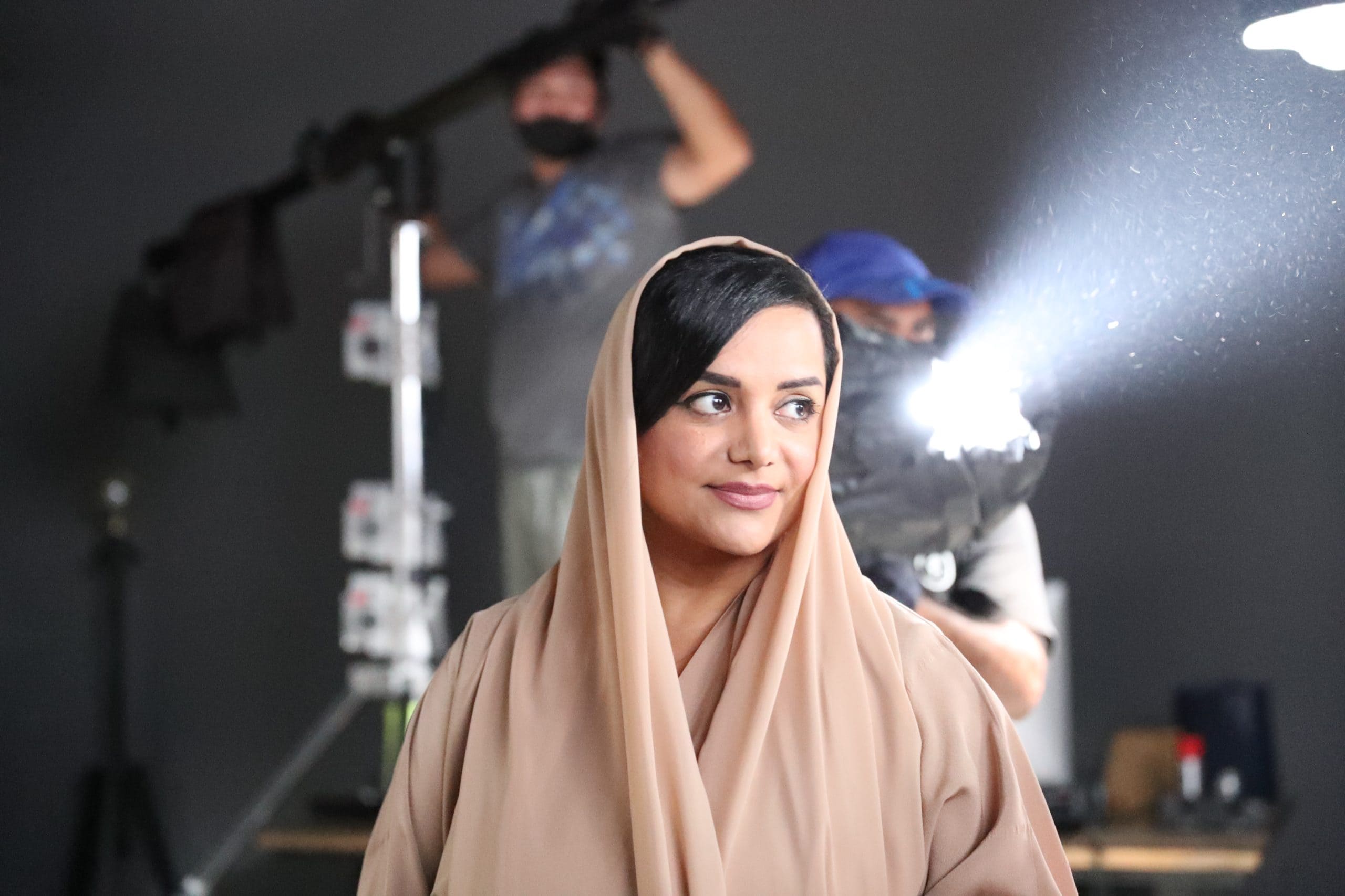 Nayla Al Khaja on a film set with the crew and camera equipment