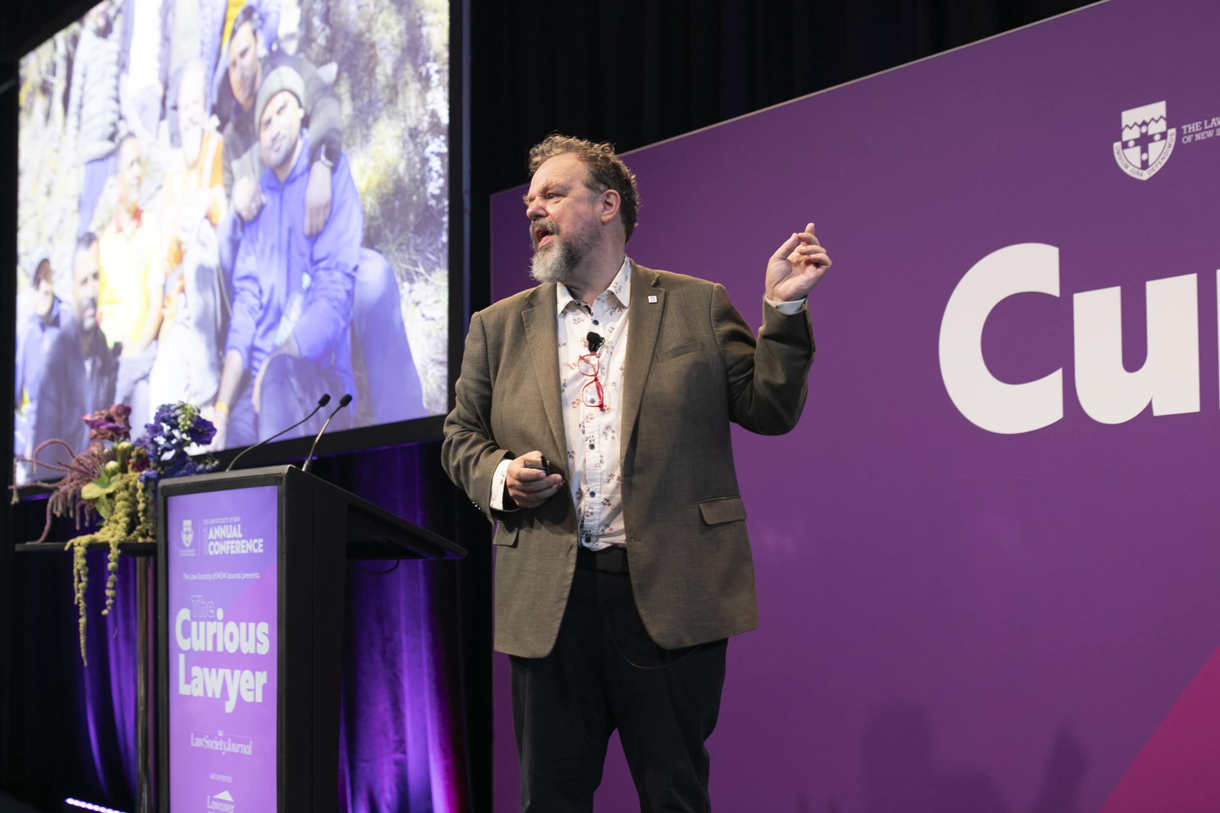 Arnold Dix speaking on stage at the Curious Lawyer conference