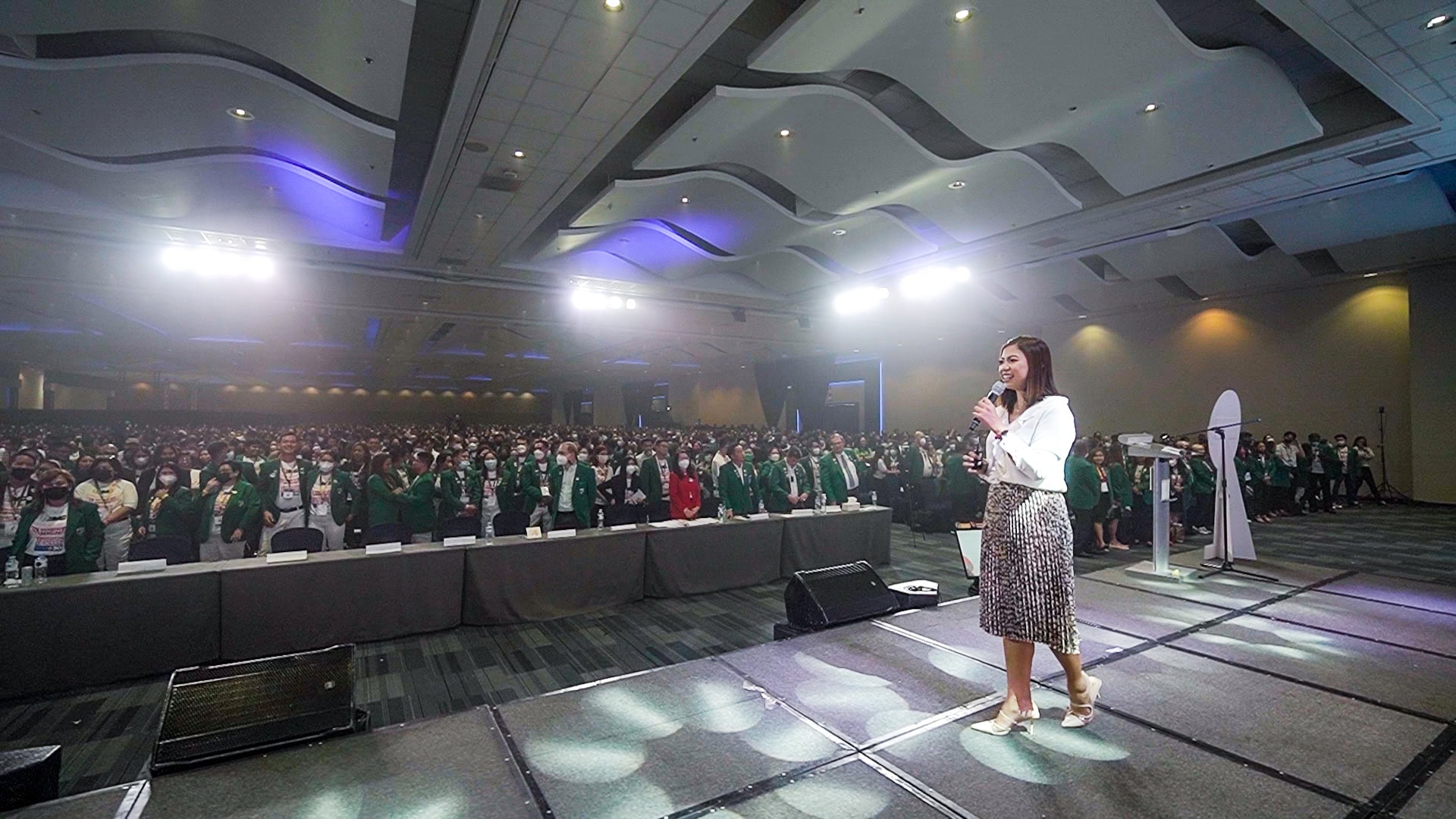 Sha Nacino speaking to a large conference audience