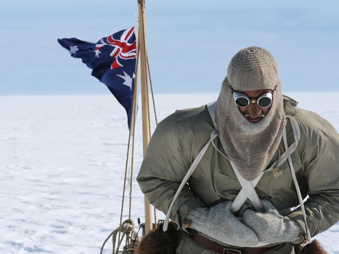 Tim Jarvis in polar gear beside an Australian flag