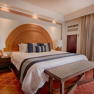 A spacious bedroom featuring a large bed and a wide window allowing natural light to fill the room.