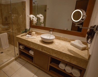 A bathroom featuring a sink, mirror, and shower, showcasing a clean and modern design.