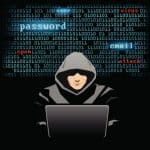 Cybersecurity threat with hacker in hoodie working on laptop.