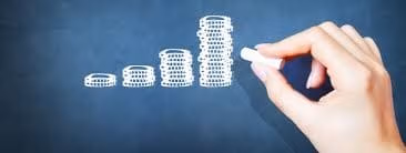 Hand drawing ascending bar graph on chalkboard, symbolizing growth and progress.