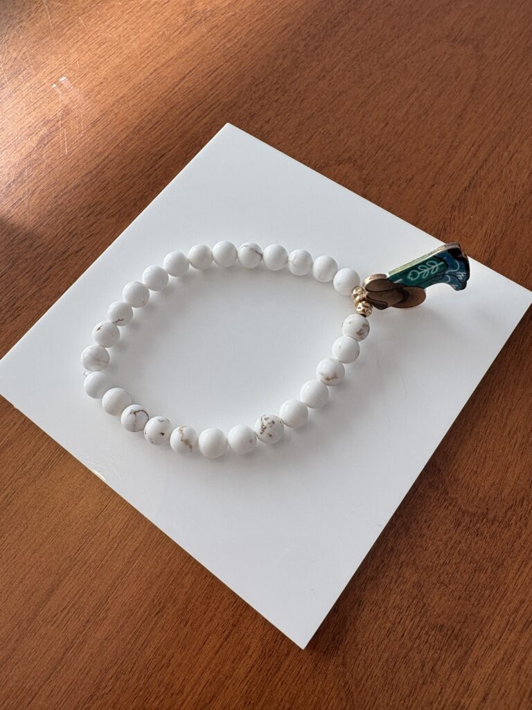 Handmade magnesite bracelet with a green cowboy boot and hat charm at the center.