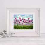 a giclee print of a field of pink vibrant tulips standing tall in a green field. The sky behind them is soft blue with fluffy clouds