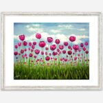 a giclee print of a field of pink vibrant tulips standing tall in a green field. The sky behind them is soft blue with fluffy clouds