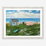 giclee print of seal island nova scotia featuring a shanty, a clothesline with clothes and a quilt and a green cart on a rocky field.