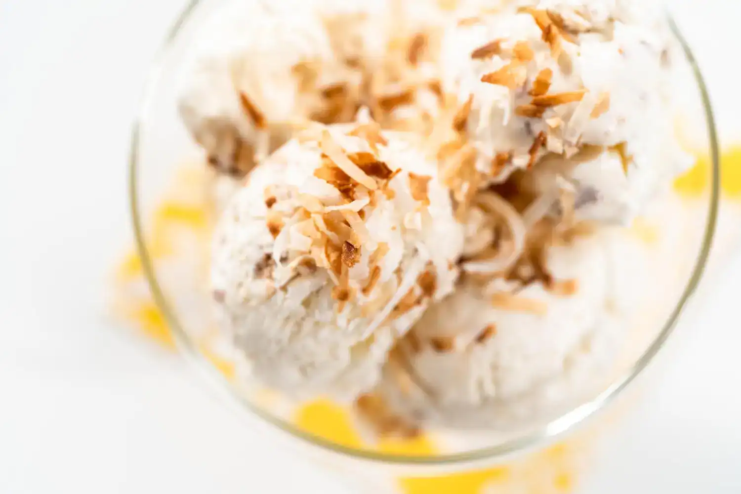 Almond milk vanilla bean ice cream served in a glass, topped with toasted coconut flakes. Perfect fo.