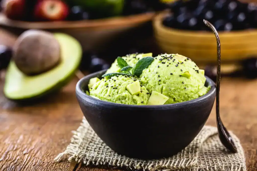 Avocado lime sorbet in a black bowl, perfect for a healthy dessert.