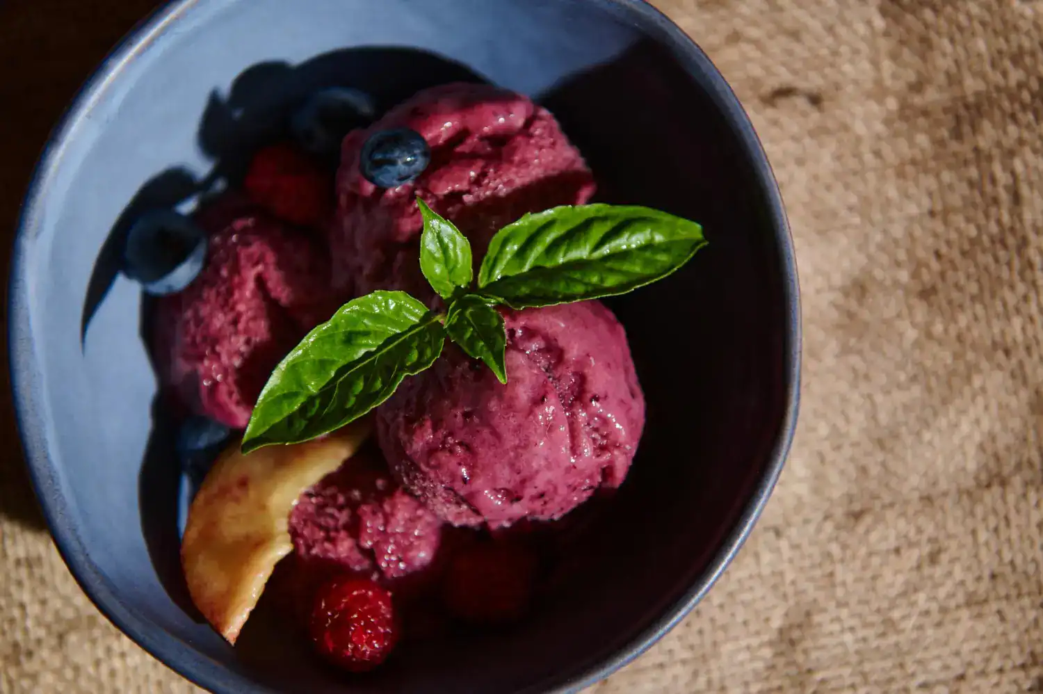Blackberry Merlot Sorbet with fresh berries and mint garnish in a black bowl.