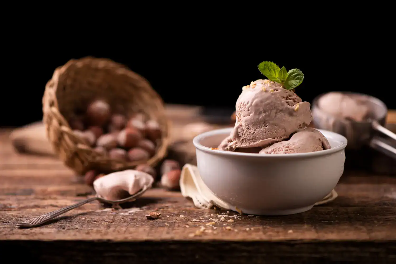 Keto chocolate hazelnut ice cream in a white bowl with fresh mint garnish. Perfect for low-carb, ket.