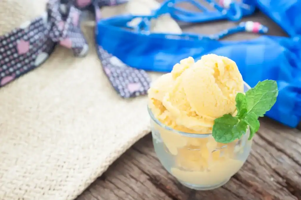 Lemon sorbet in a glass garnished with mint, perfect for keto dessert lovers.
