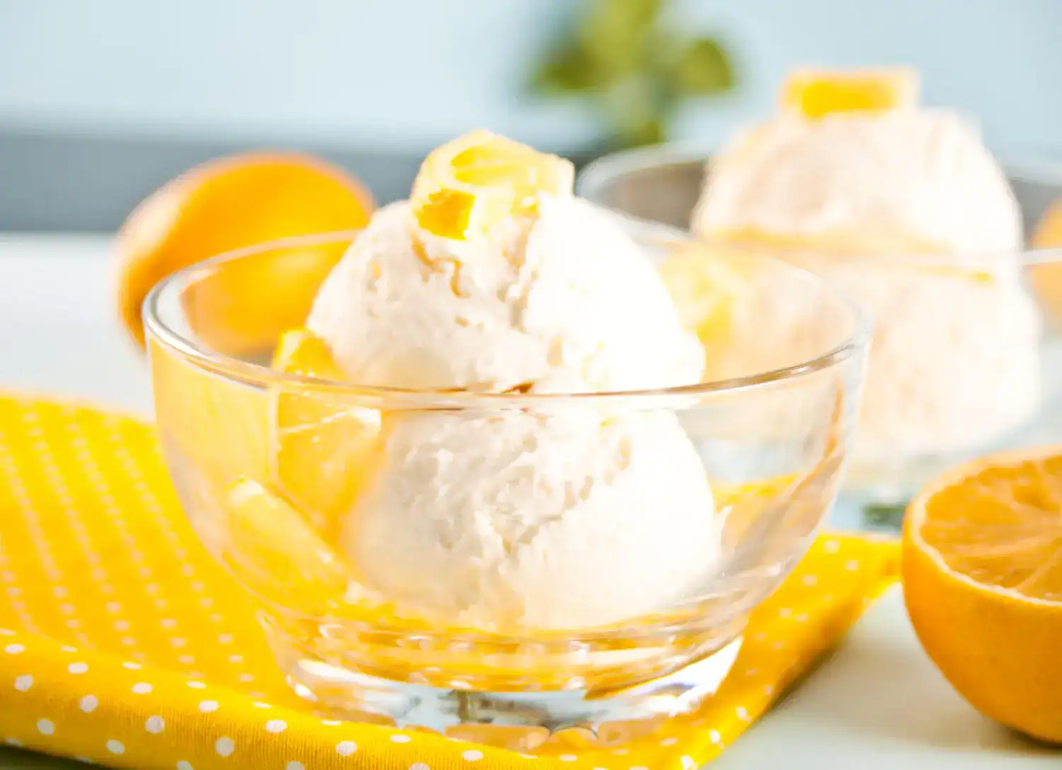 Keto Orange Creamsicle ice cream in a glass bowl with fresh oranges. Perfect for a healthy, creamy d.