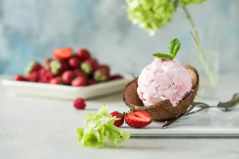 Delicious keto strawberry cheesecake ice cream served in a coconut shell, perfect for low-carb desse.