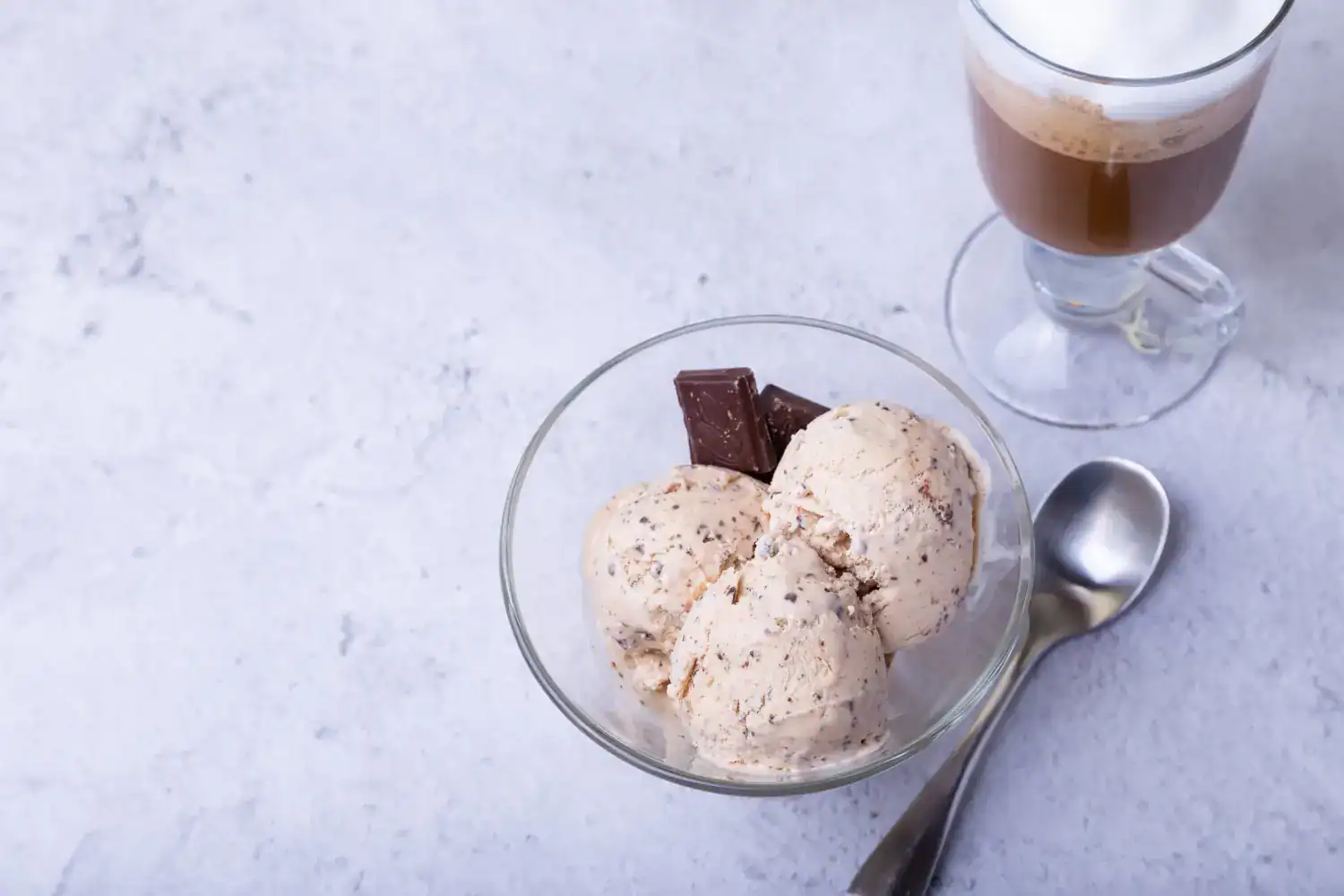 Delicious homemade oat milk cinnamon ice cream served in a glass bowl with chocolate pieces. Perfect.