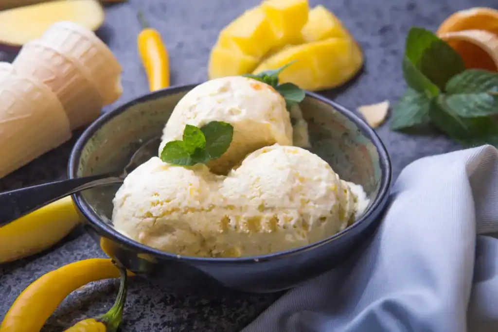 Passion Fruit Ice Cream with Fresh Mango and Mint Garnish.