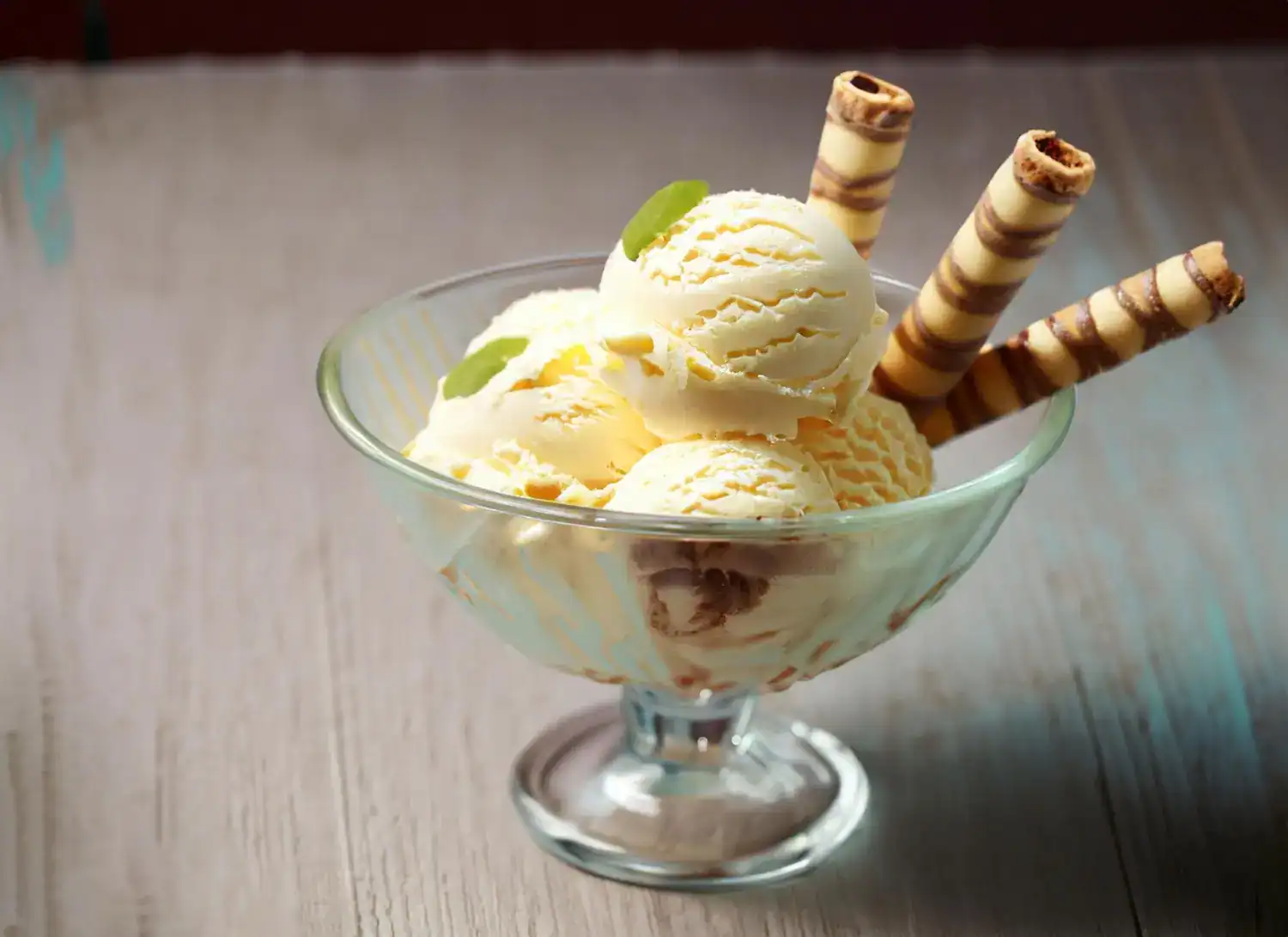 Delicious low-calorie pear ginger sorbet served in a glass bowl with wafer rolls and fresh mint. Per.