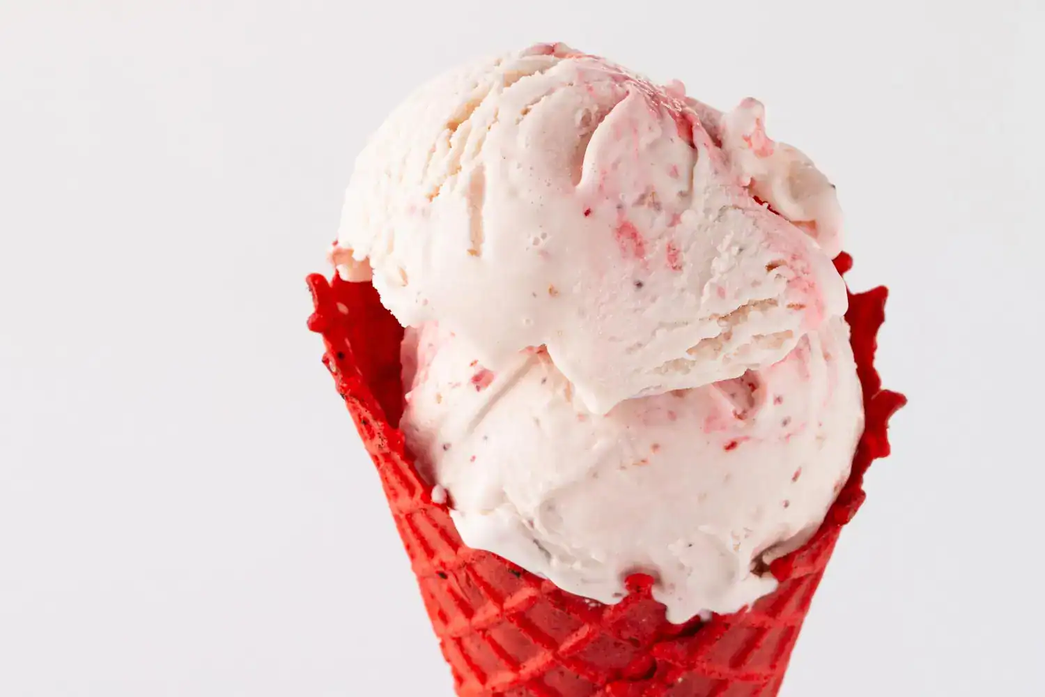 Delicious white chocolate raspberry ice cream in a vibrant red cone, perfect for a sweet treat or de.
