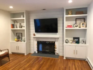 Custom Built in Millwork with Shiplap Wall and Flanking Bookcases Around a Fireplace in Locust Valley Nassau County by Creatively Done Homes Improvements