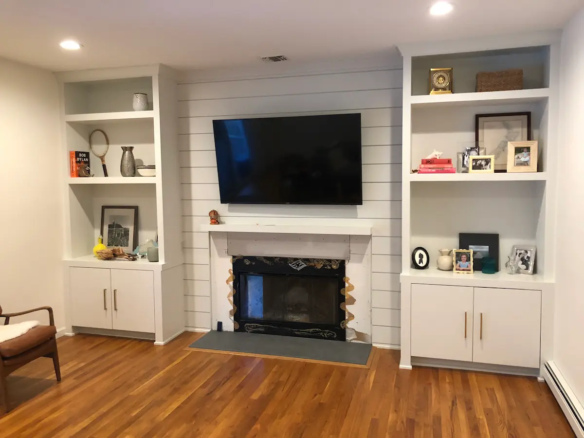 Custom Built in Millwork with Shiplap Wall and Flanking Bookcases Around a Fireplace in Locust Valley Nassau County by Creatively Done Homes Improvements