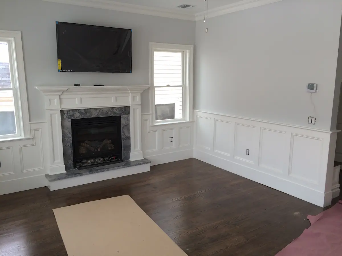Fireplace built-in with raised hearth and wainscoting in Nassau County by Creatively Done Homes Improvements