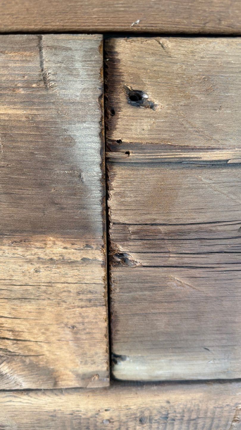 Close up of hand distressed butt joint and knot detail on reclaimed barn wood wall installation by Creatively Done Homes Improvements
