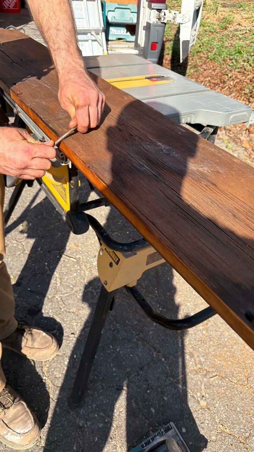 Hand rolling stain on milled edges of reclaimed barn wood boards by Creatively Done Homes Improvements