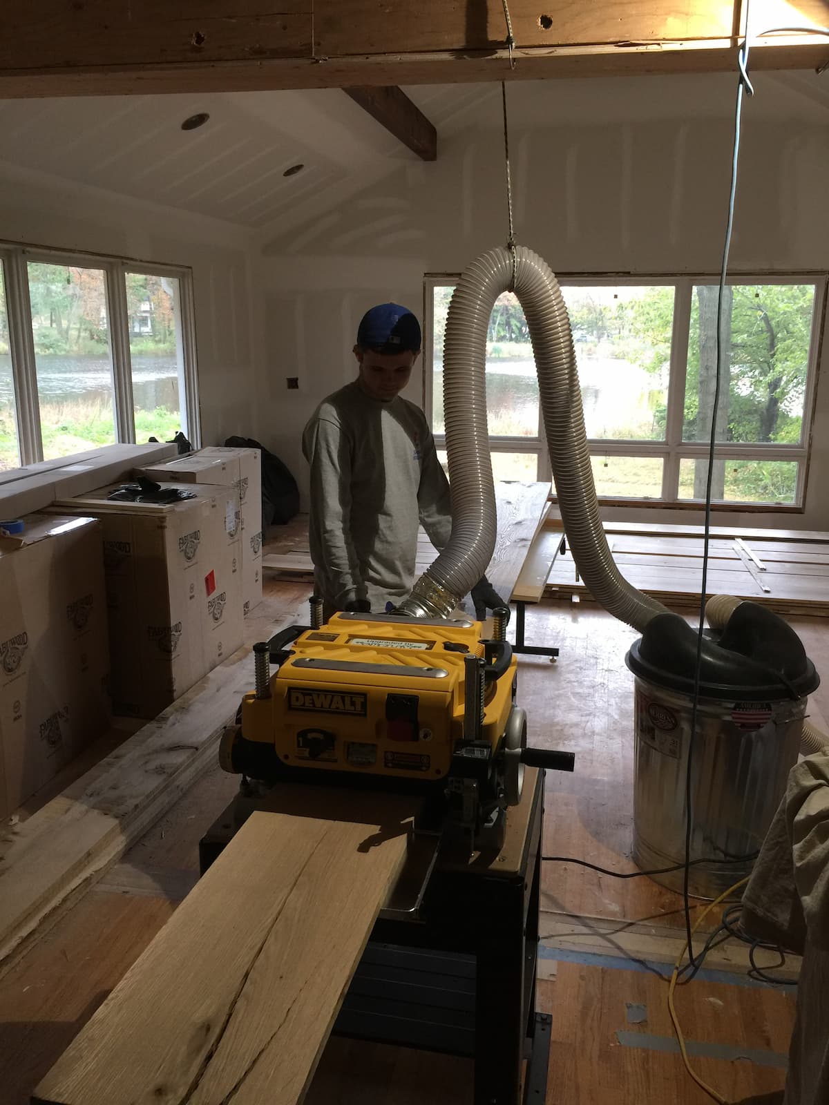 Matthew Cullen of Creatively Done Homes Improvements operating the DeWalt planer during on-site white oak beam wrapping in Sea Cliff NY