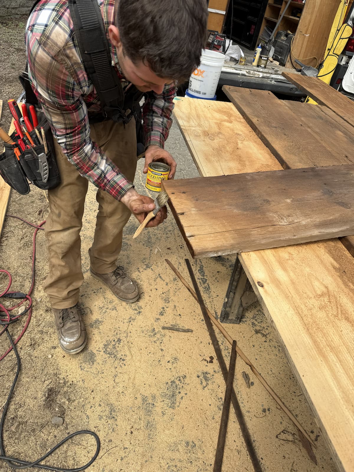 Matthew staining cut edges of reclaimed barn wood planks with Minwax before installation by Creatively Done Homes Improvements