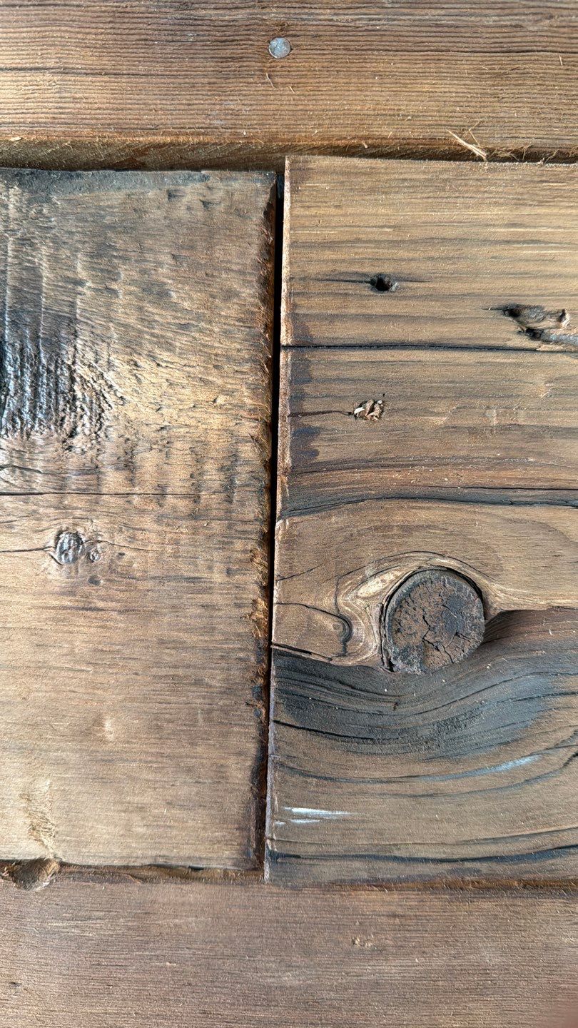 Hand distressed butt joint on reclaimed barn wood wall showing color matched stain blending seamlessly by Creatively Done Homes Improvements