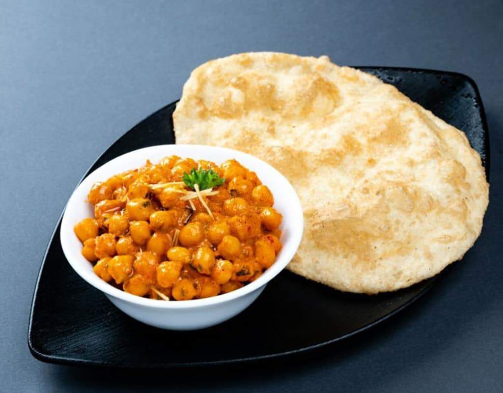 Spicy chickpea curry with naan bread, authentic Indian cuisine from Crown Indian Cuisine.