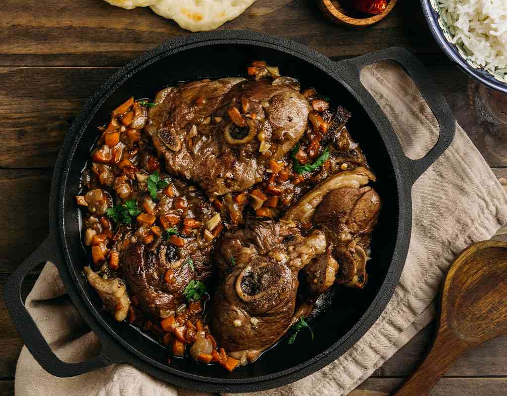Succulent Indian lamb curry with vegetables in a cast iron skillet for authentic Indian cuisine.
