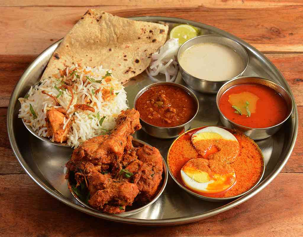 Flavorful Indian Thali with rice, curry, naan, and spiced vegetables at Crown Indian Cuisine.