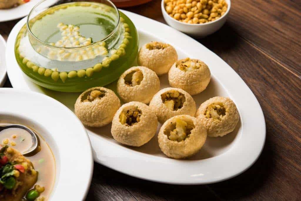 Golden fried Indian snacks served with green chutney, showcasing authentic Crown Indian Cuisine flavors.