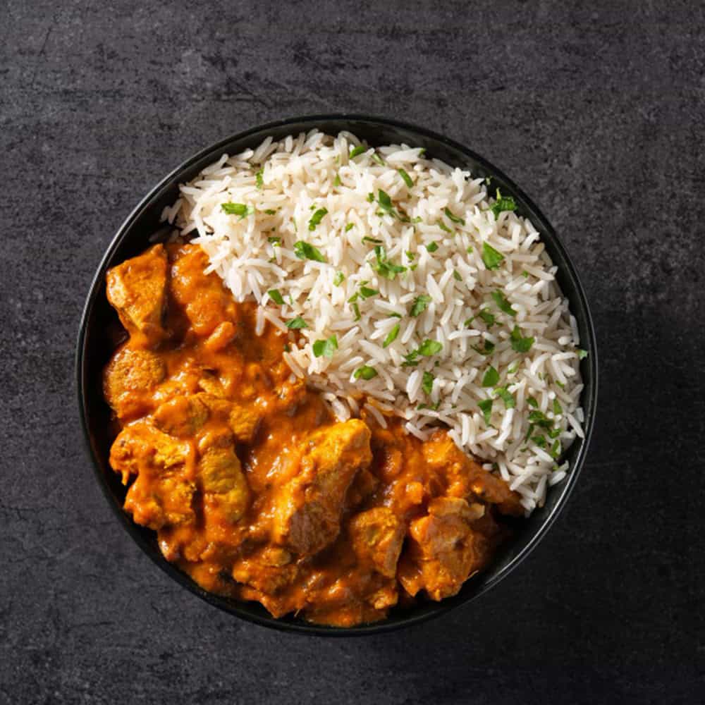 Steamed rice with Indian curry in a black bowl at Crown Indian Cuisine Windang.