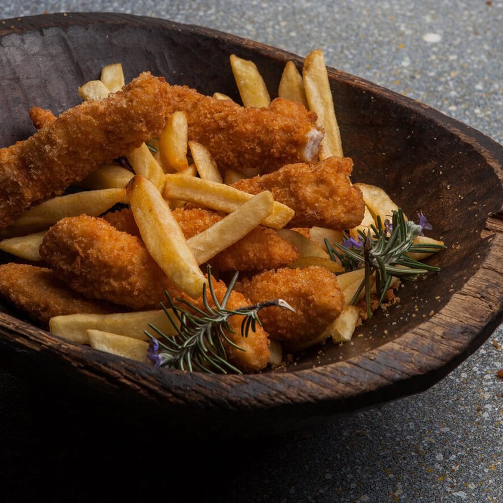 Crispy fried fish and French fries in a rustic wooden bowl, garnished with rosemary, served at Crown Indian Cuisine Windang.