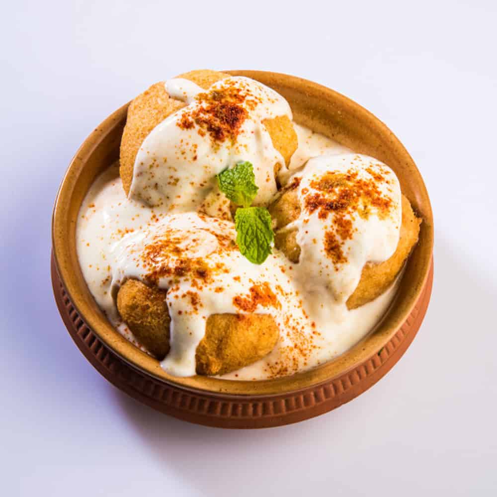 Creamy Indian dessert with ice cream, garnished with spices and mint leaves.