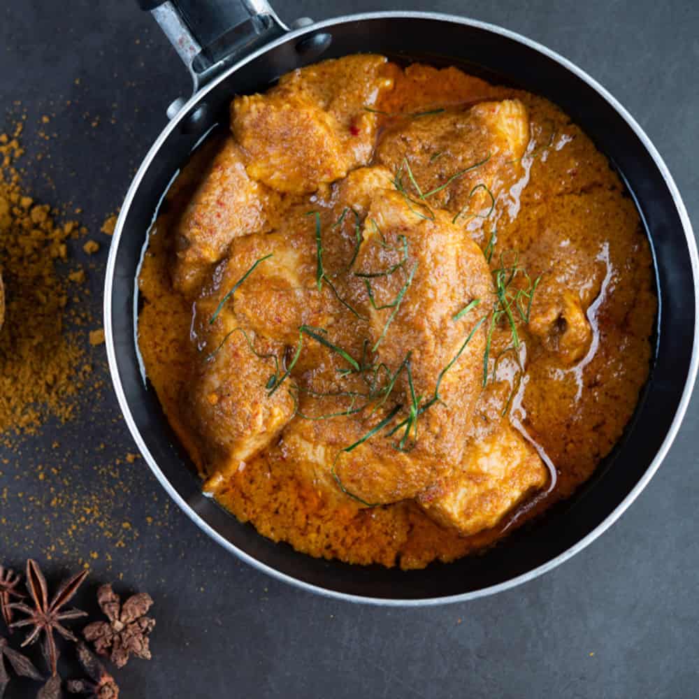 Spicy Indian chicken curry in a black skillet at Crown Indian Windang.