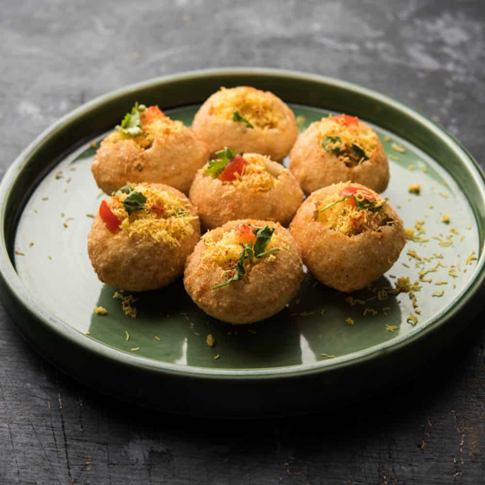 Crispy Indian vegetarian appetizers on green plate, delicious Indian cuisine at Crown Indian Windang.