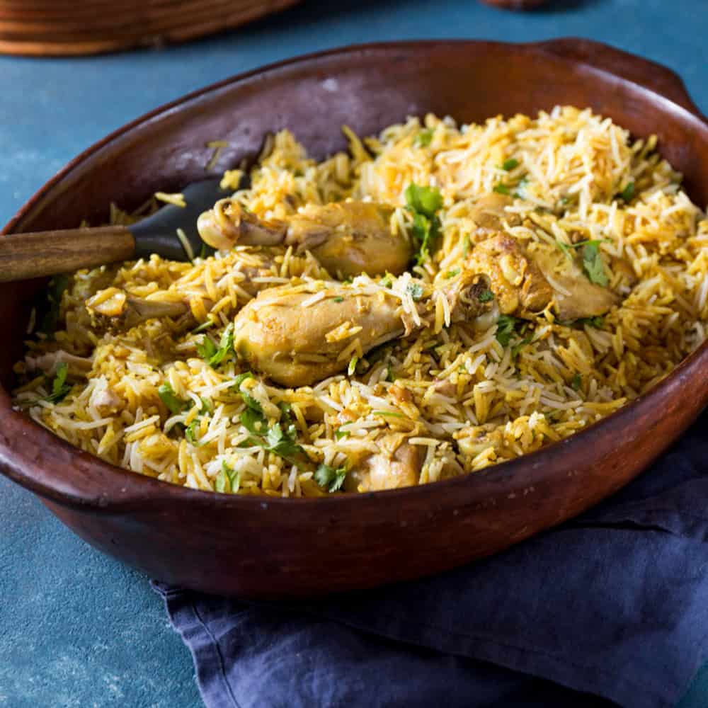Rich Indian chicken biryani with aromatic spices and basmati rice in a traditional clay pot.