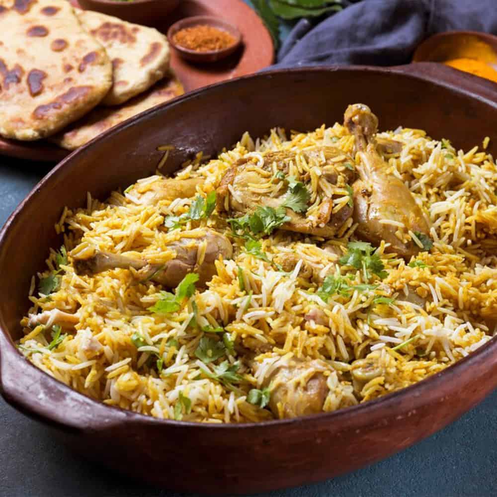 Steamed biryani with chicken, served with naan bread and flavorful spices at Crown Indian Cuisine Windang.