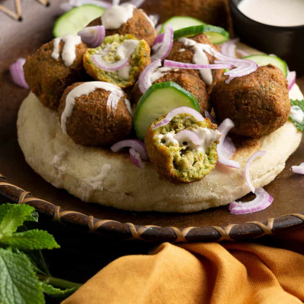 Crispy vegetarian falafel with cucumber and onion on naan bread.
