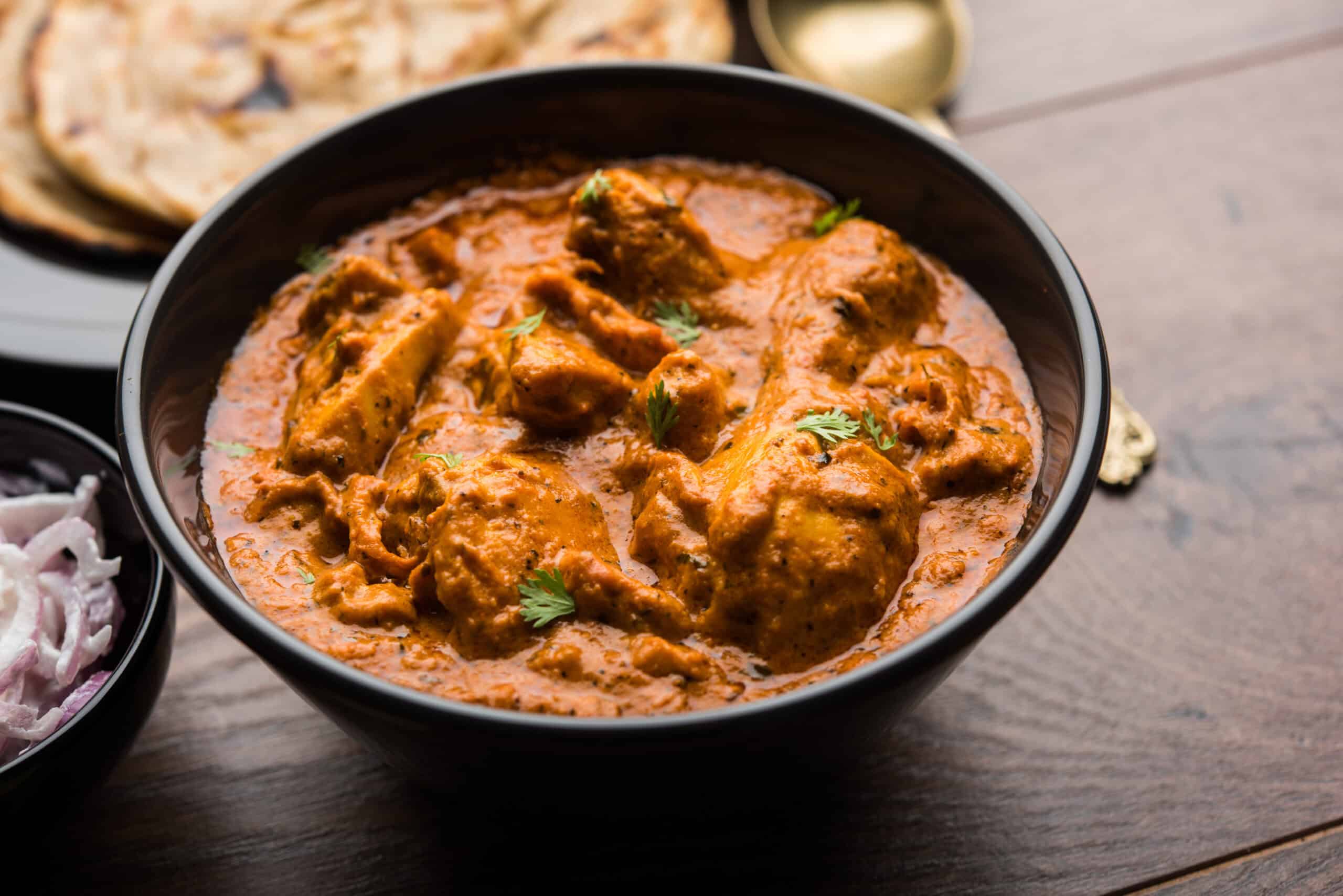 Creamy Indian chicken curry in black bowl, authentic Indian cuisine Windang.