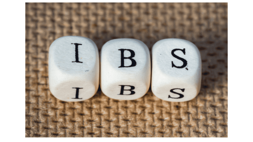 Three white dice spelling IBS on a textured brown background.