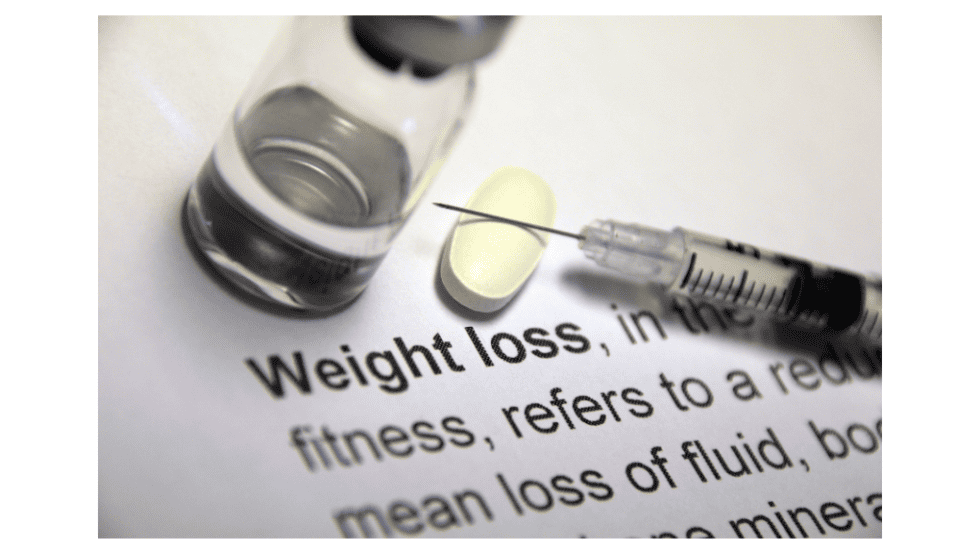 Hypnotherapy session with a syringe, pill, and weight loss text on paper.