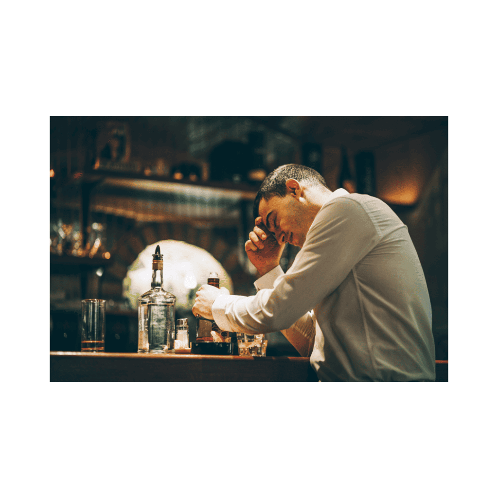 Man seated at a bar with a drink