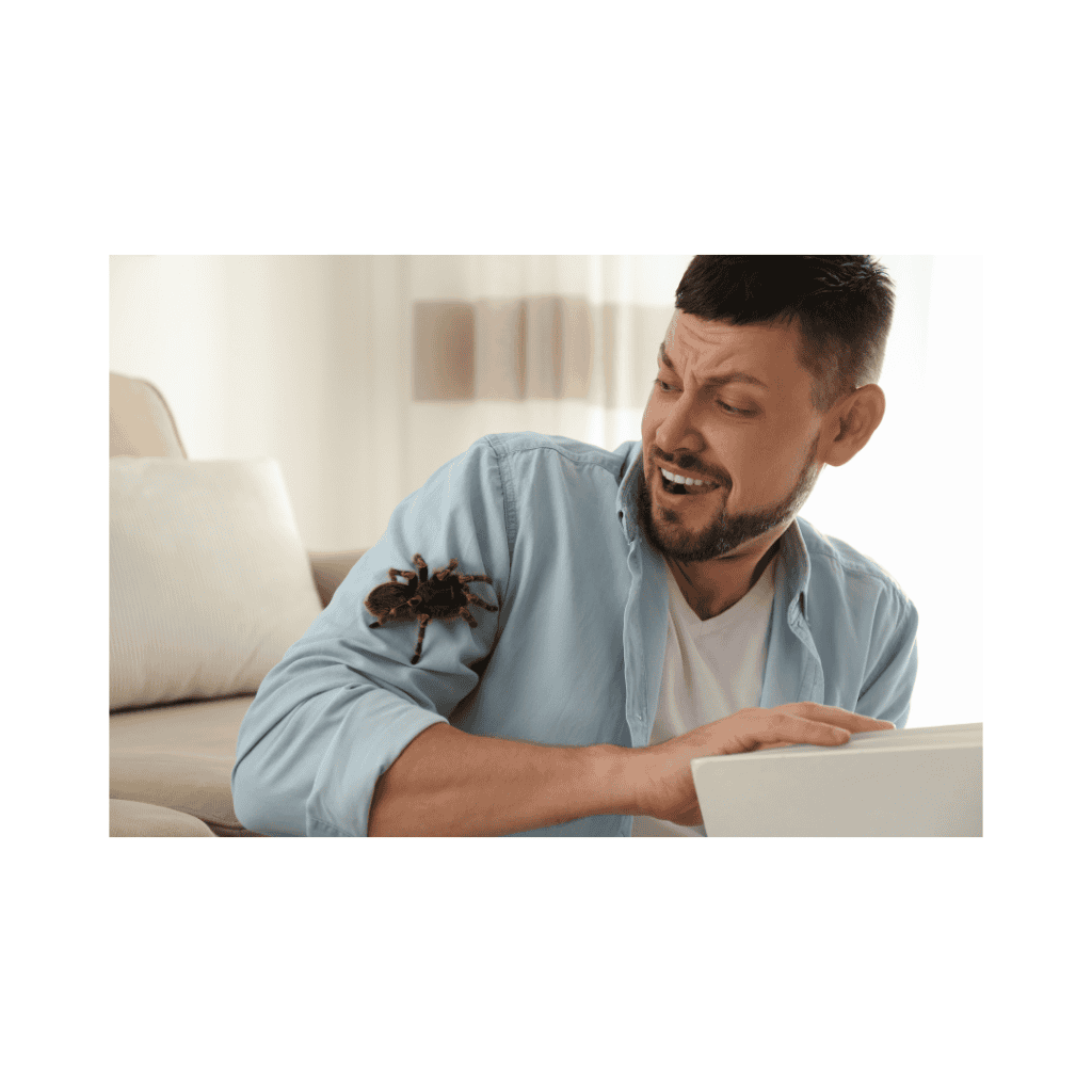 Man startled by a tarantula on his shoulder indoors.